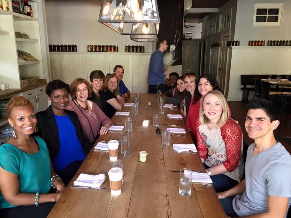 Dining group at long communal table enjoying Atlanta food tour