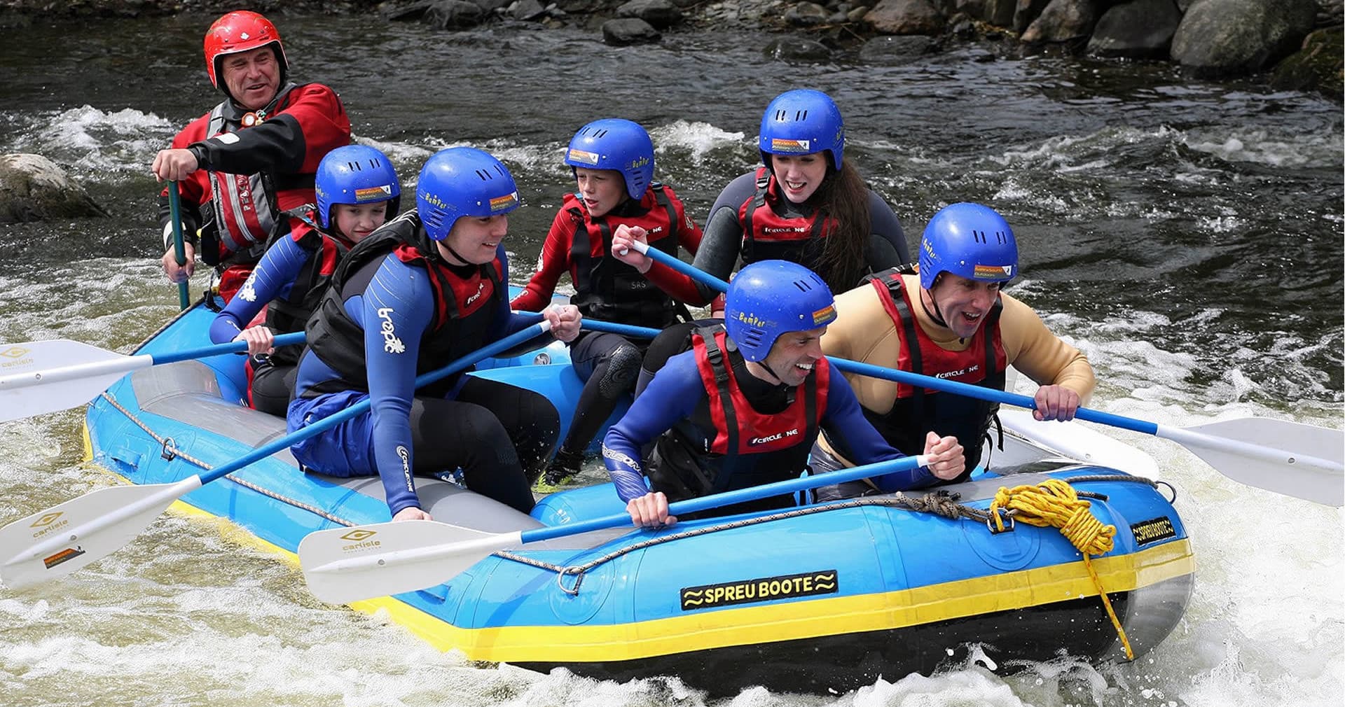 Whitewater rafting team navigating fast river rapids