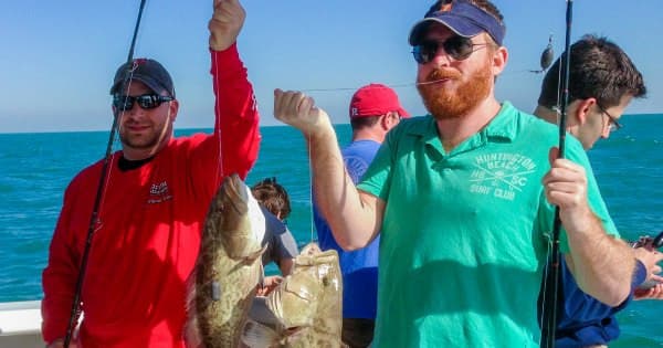 Group of anglers displaying reef fish catch on offshore fishing charter