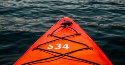 POV of orange kayak bow on open water for paddling trip