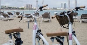 Beachfront bike rentals parked on Barcelona beach near skyline