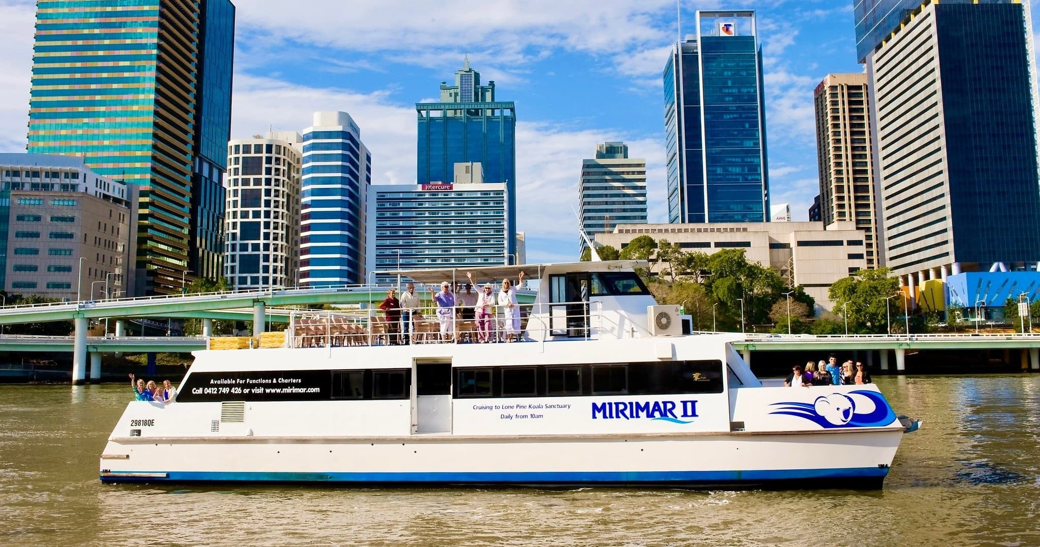 River cruise boat passing city skyline on Brisbane River tour