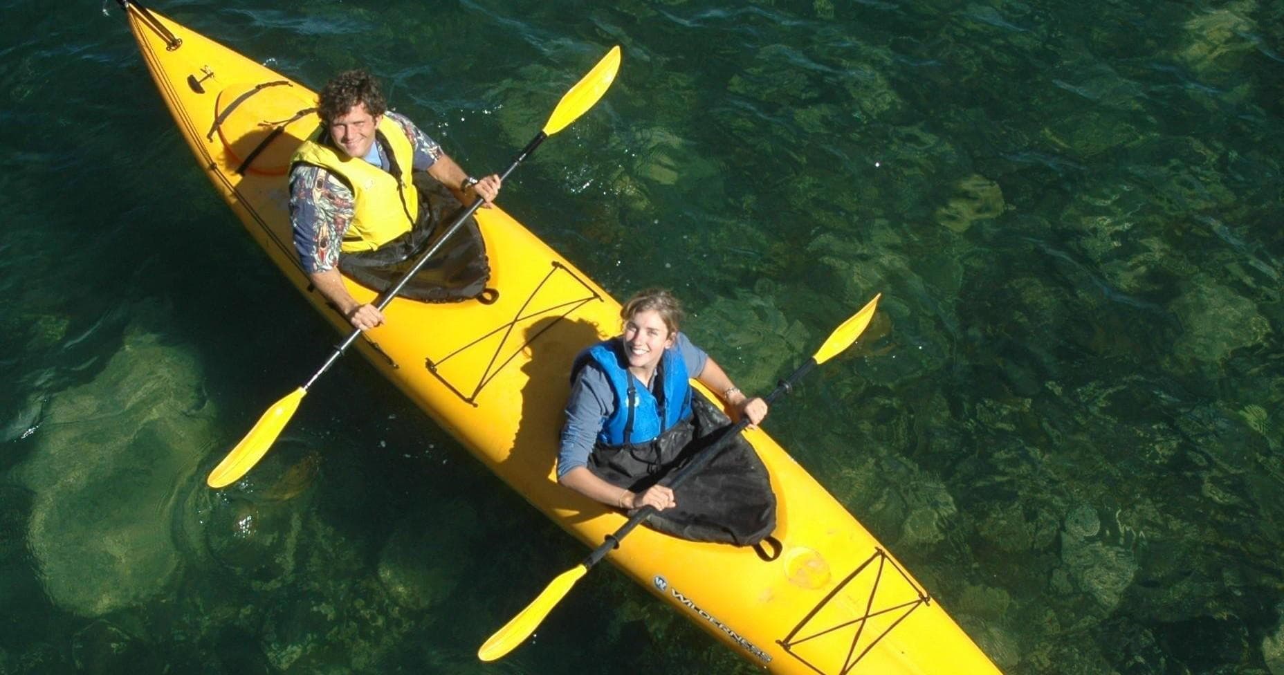 Aerial view of tandem yellow kayak over clear coastal water