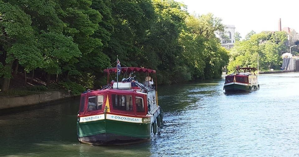 Tour boat cruising tree-lined Lockport canal, scenic ride