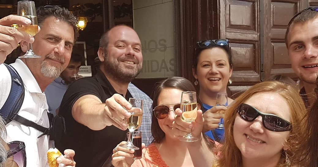 Friends toasting on Madrid tapas tour outside a bar