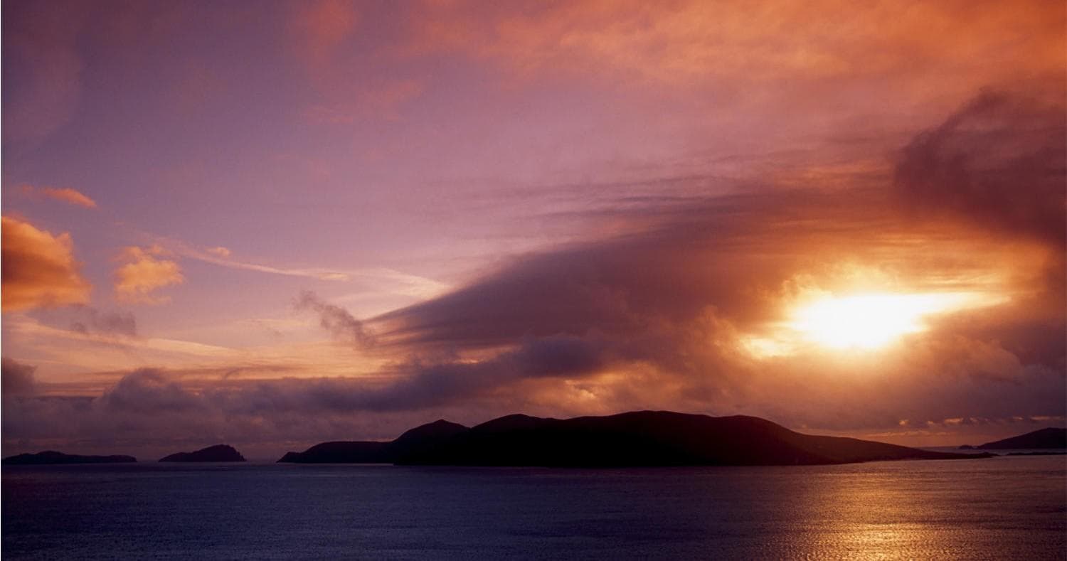 Sunset over coastal islands and calm Atlantic sea at dusk