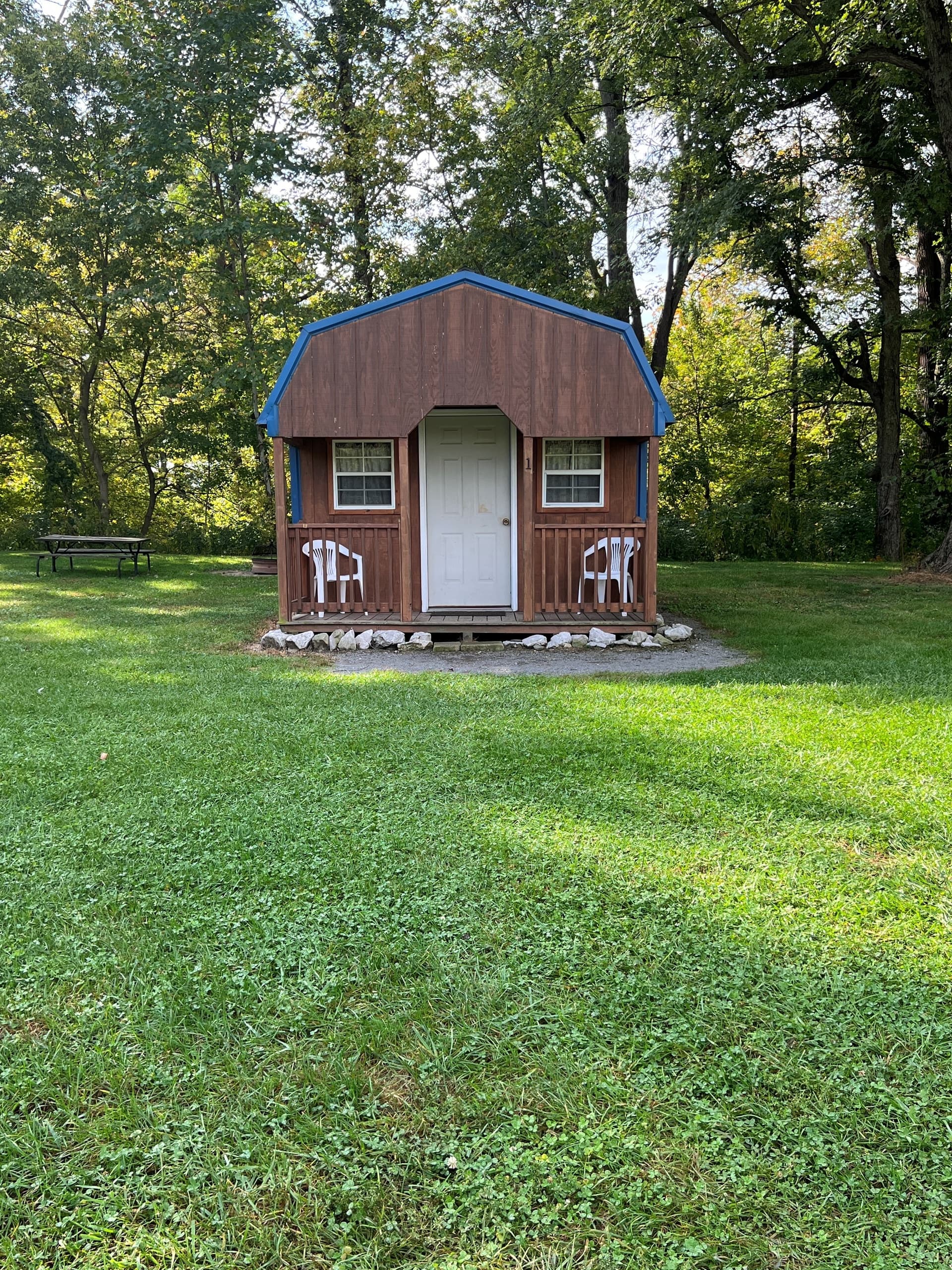Small rustic cabin with porch and picnic area by the woods
