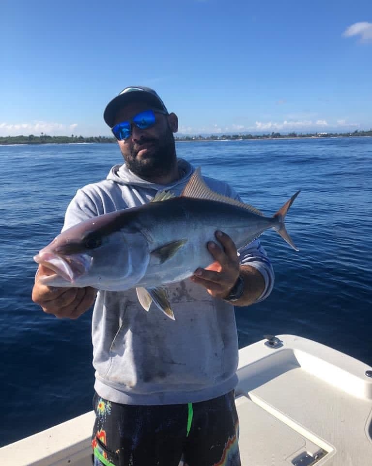 Angler holding offshore kingfish on sportfishing boat