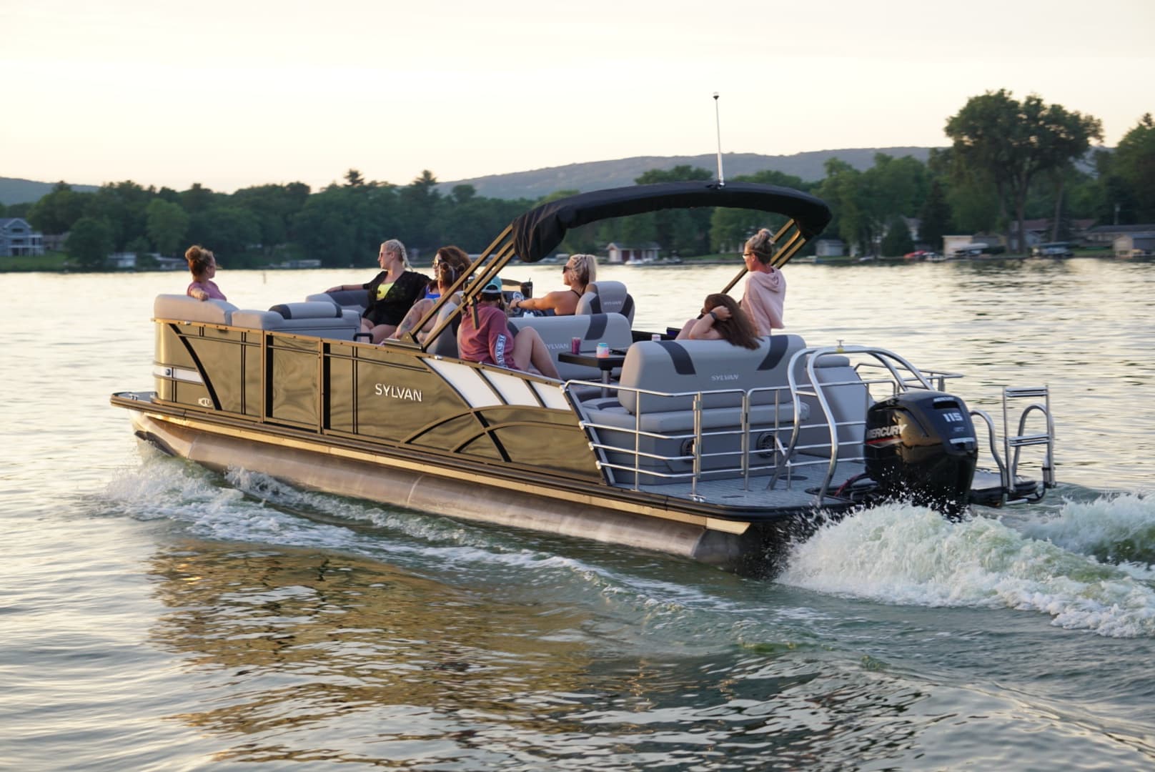 Group on a pontoon boat cruising a scenic sunset lake