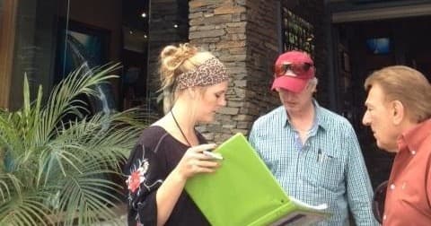 Guide briefing players with folder outside storefront during city scavenger hunt