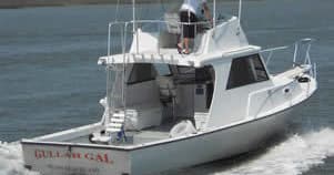 Sportfishing cabin cruiser backing into sea on coastal charter trip
