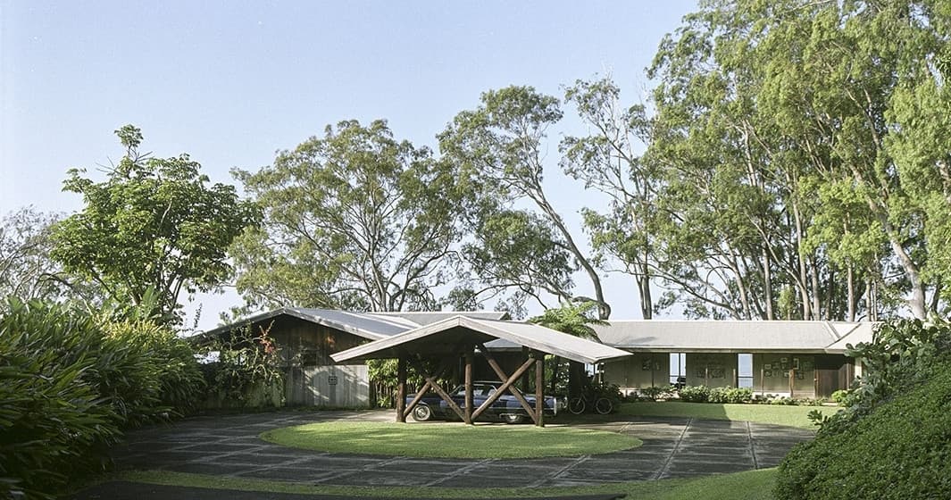 Tropical ranch house amid lush trees and landscaped grounds