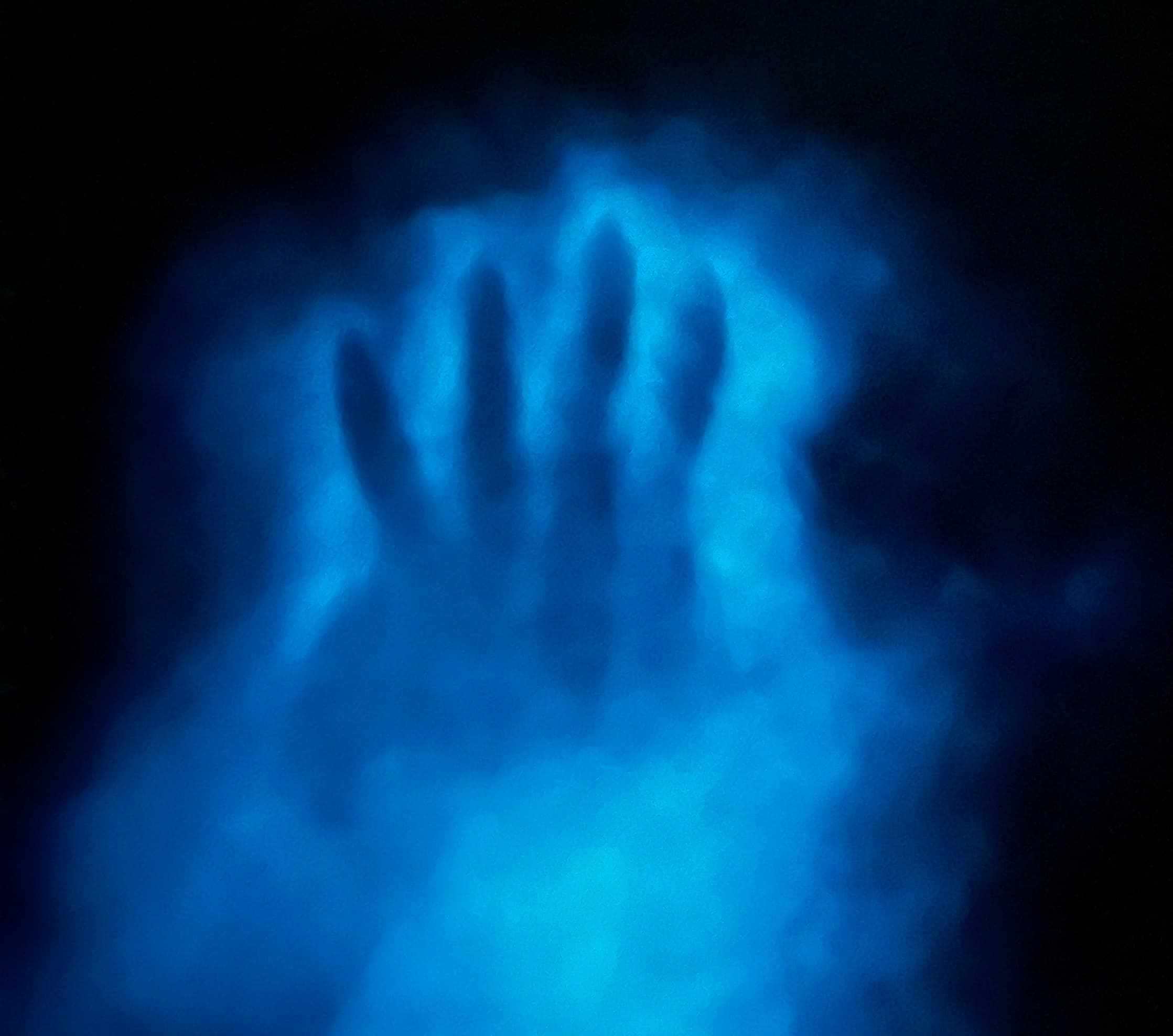 Blue bioluminescent hand-shaped glow over water at night in Puerto Rico