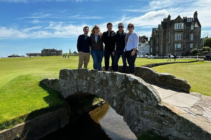 Group standing on historic stone bridge at coastal links course