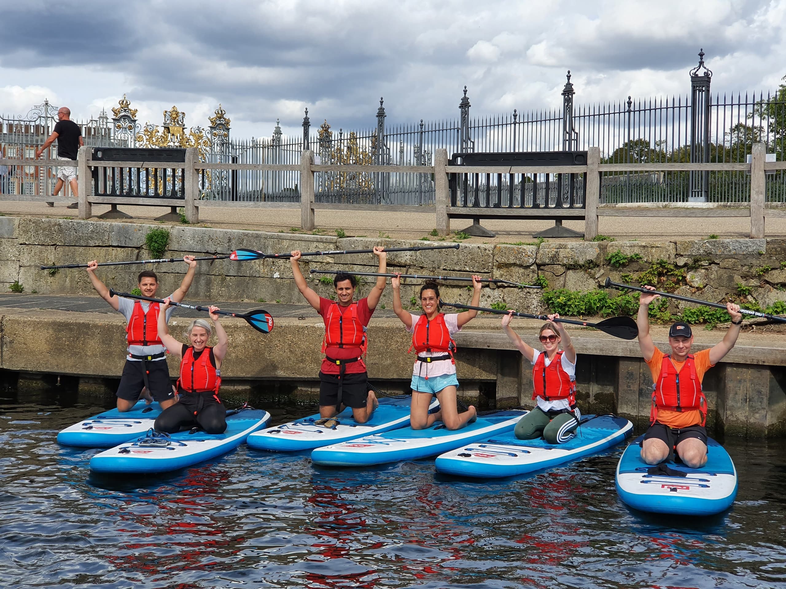 Friends celebrating on paddleboards by riverside steps