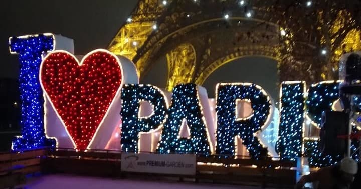 Illuminated I heart Paris sign by the Eiffel Tower at night