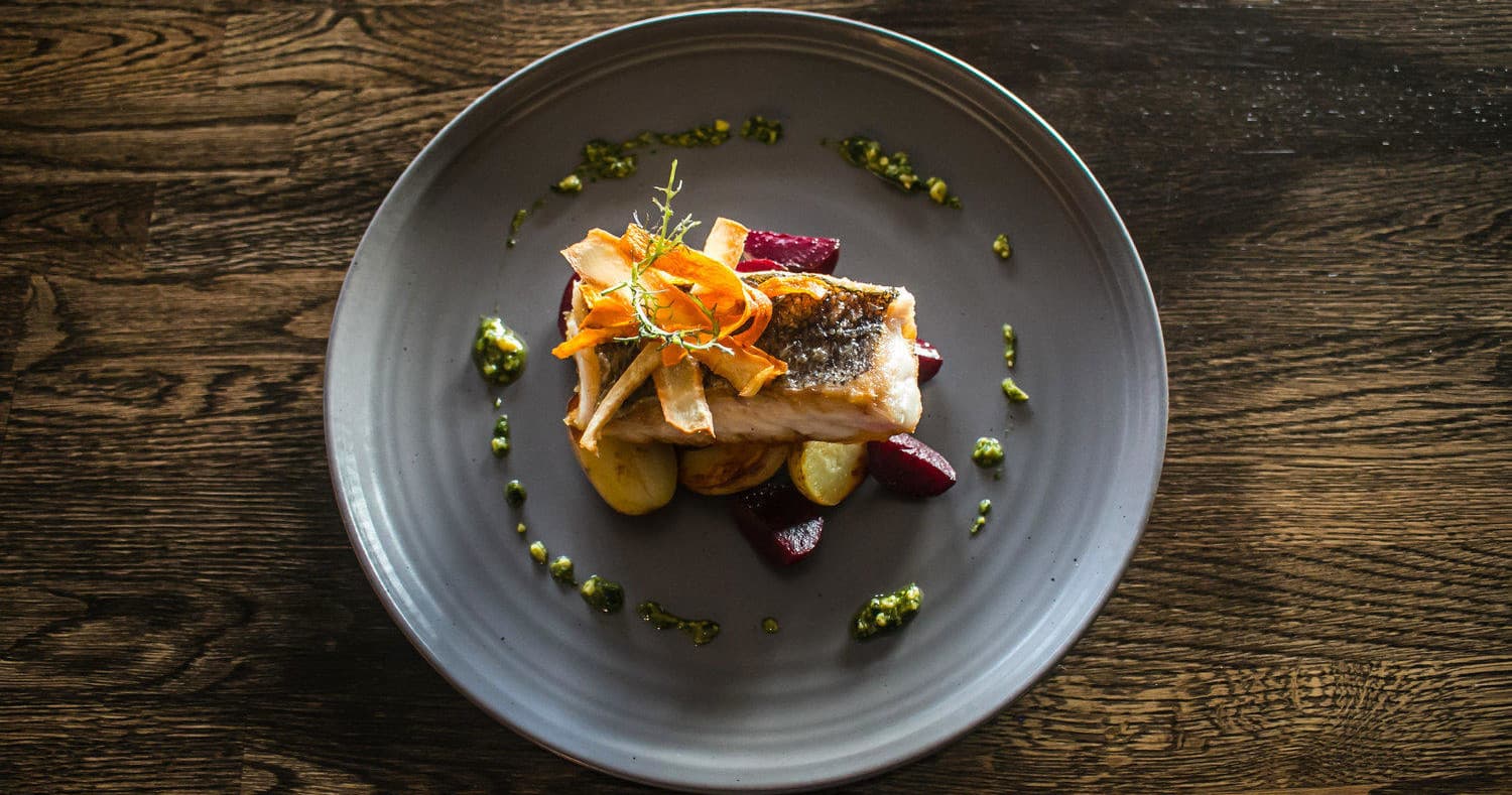 Gourmet plated seafood dish on wooden table in restaurant