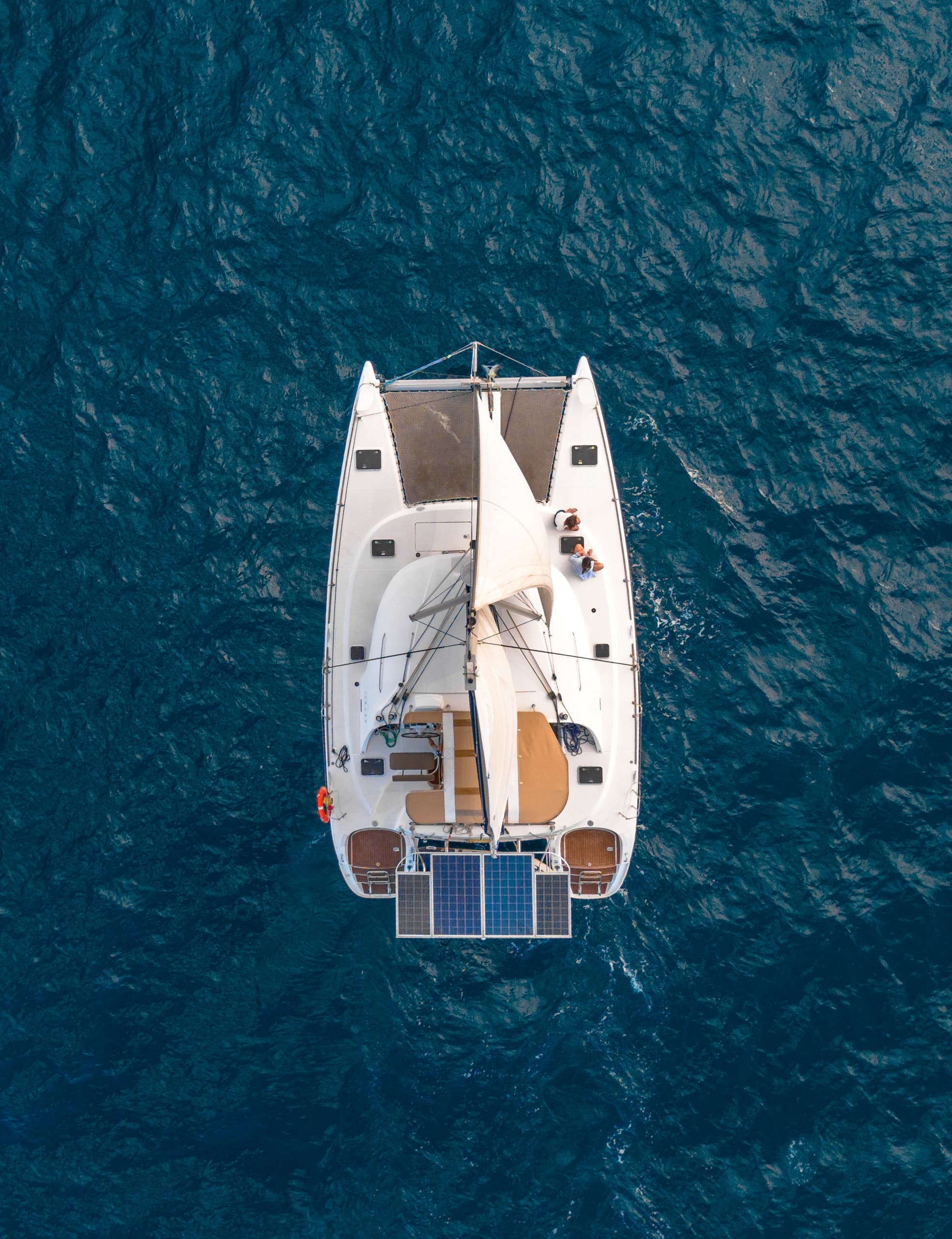 Aerial view of catamaran on deep blue sea from above for sailing