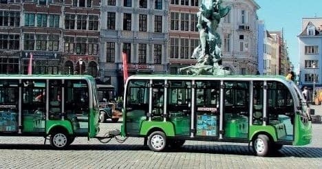 Electric green sightseeing shuttles parked in European city plaza