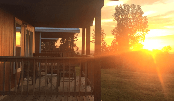 Sunset from cabin porch with golden sky and warm light