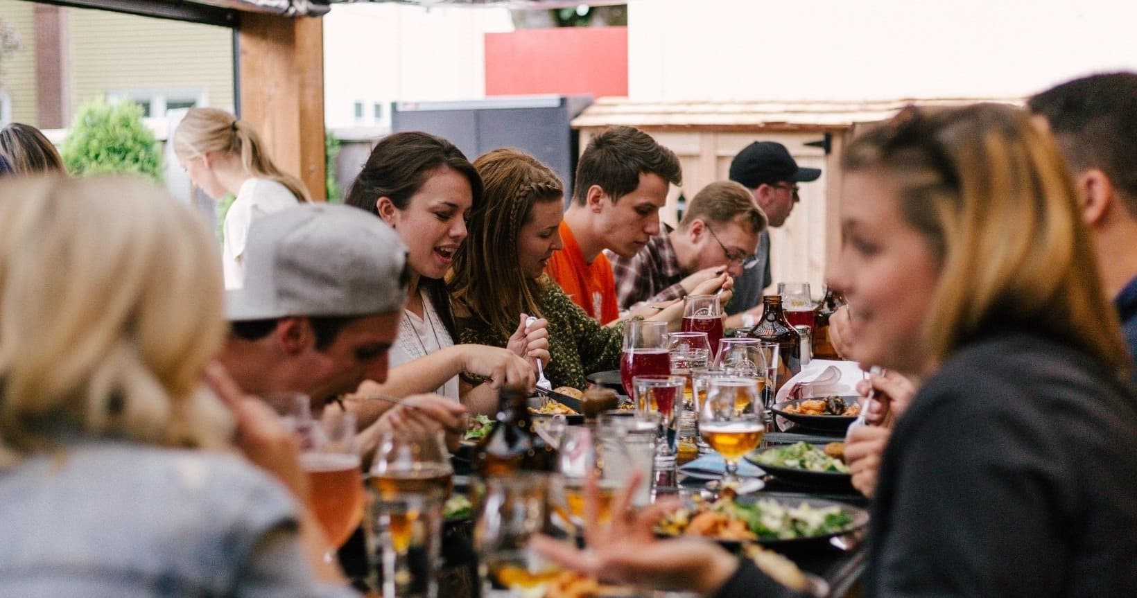Large group dining outdoors on communal patio enjoying food
