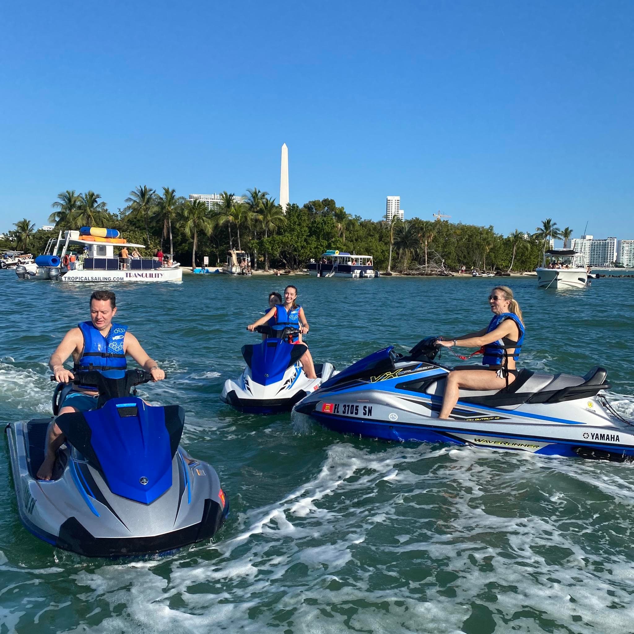 Three riders on jet skis near Miami Beach shoreline, Biscayne Bay
