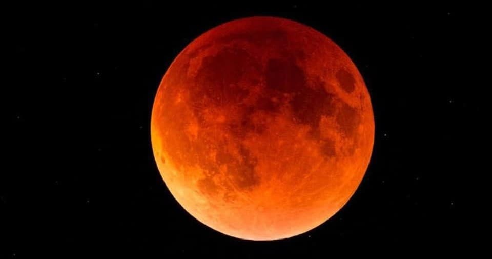 Blood moon lunar eclipse over dark sky, dramatic astronomy view