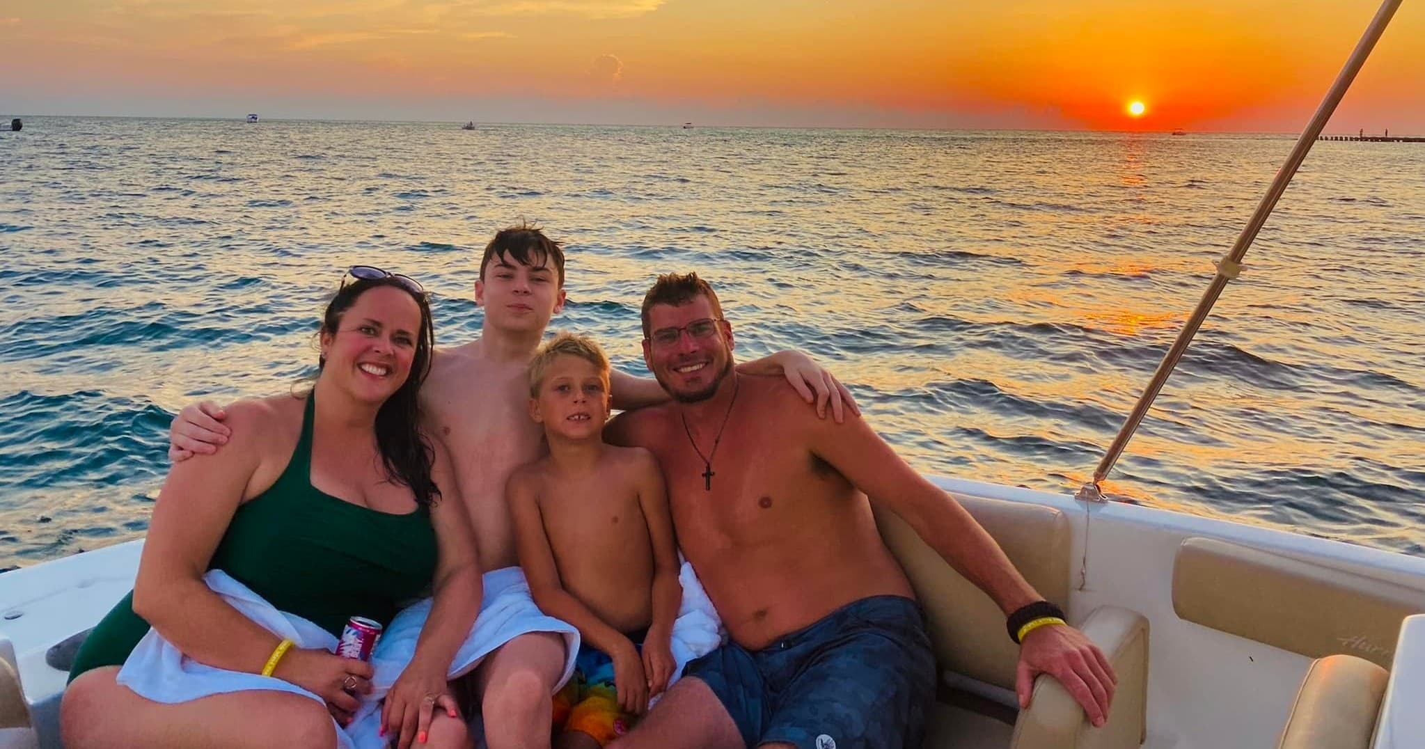 Family enjoying sunset boat cruise over calm ocean waters