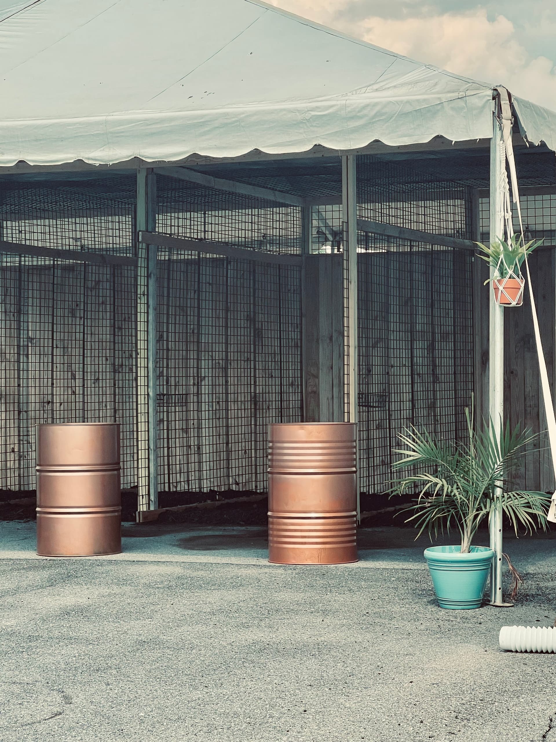 Copper barrels stored under canopy at outdoor market or staging area