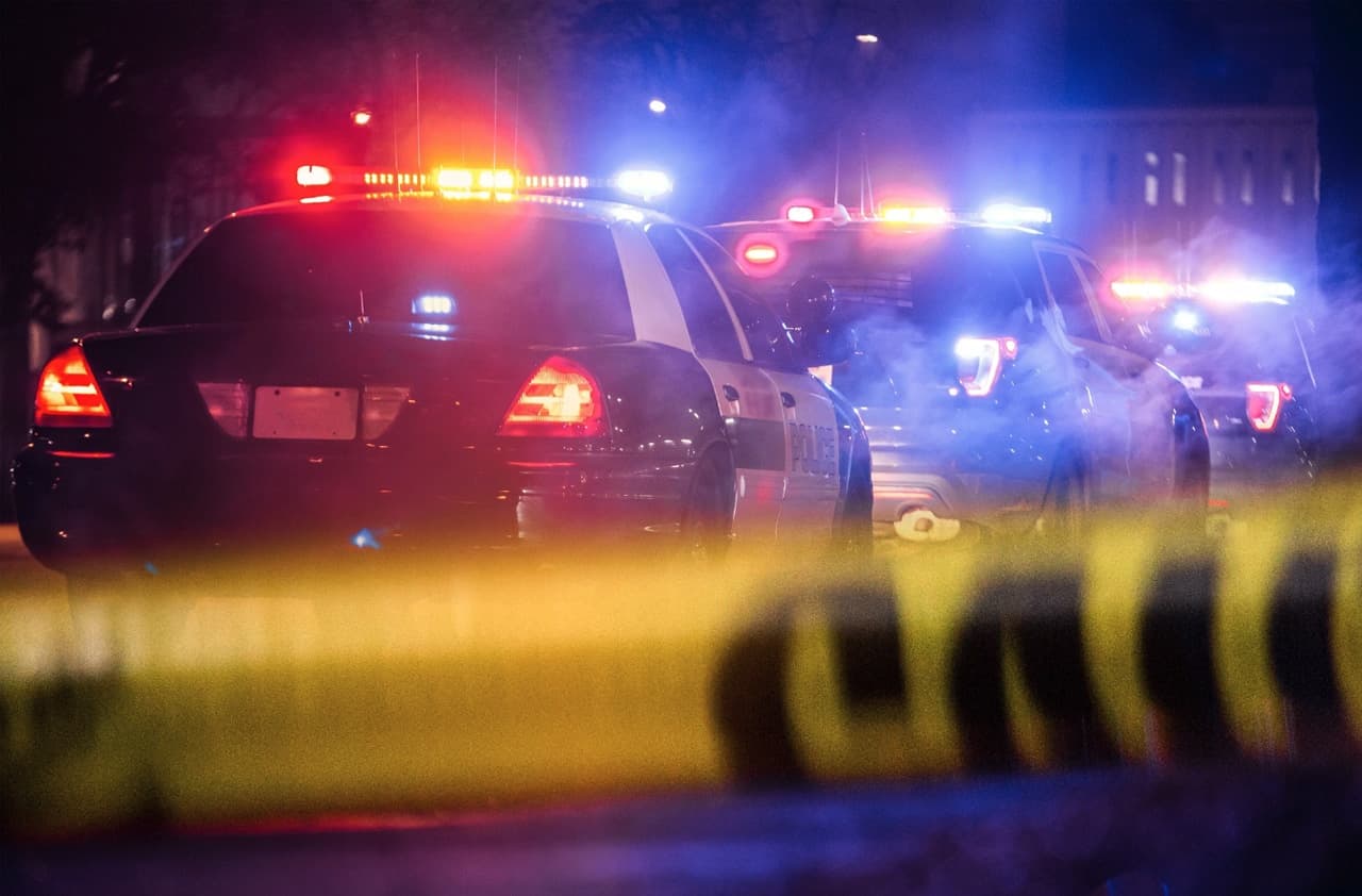 Police patrol cars with flashing lights at outdoor crime scene