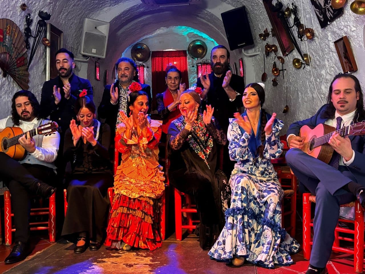 Flamenco troupe clapping and playing guitars in cave tablao