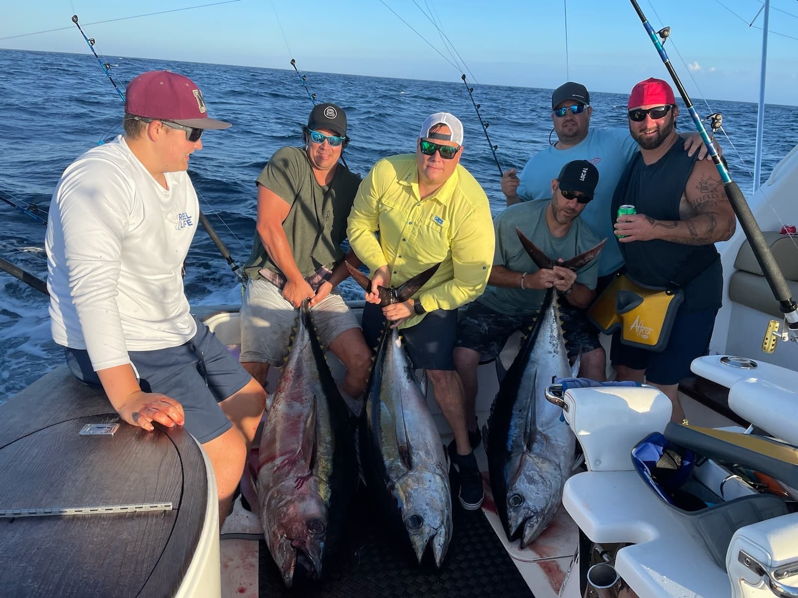 Anglers holding large tuna on deck of offshore sportfishing boat
