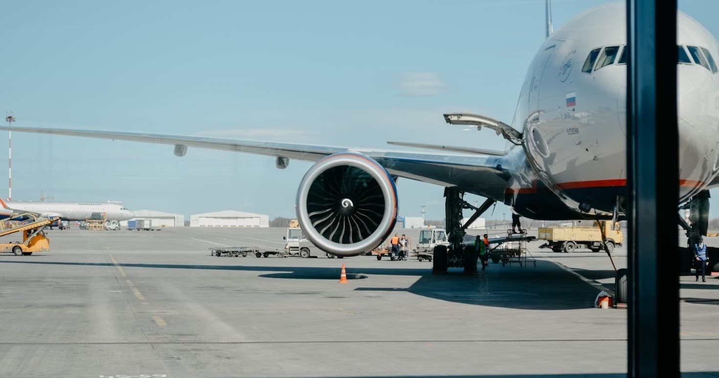 Commercial jet parked on airport tarmac at sunny terminal