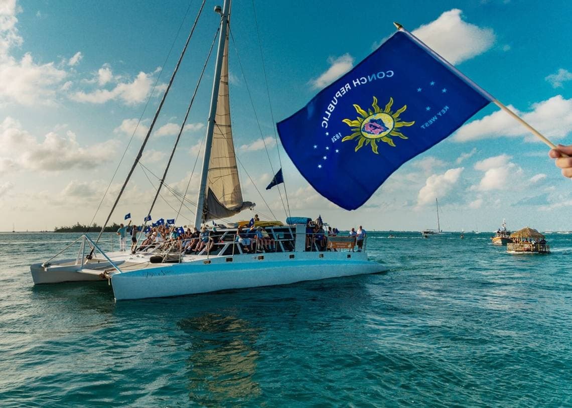 Sailboat flying bright blue flag cruising in open ocean waters