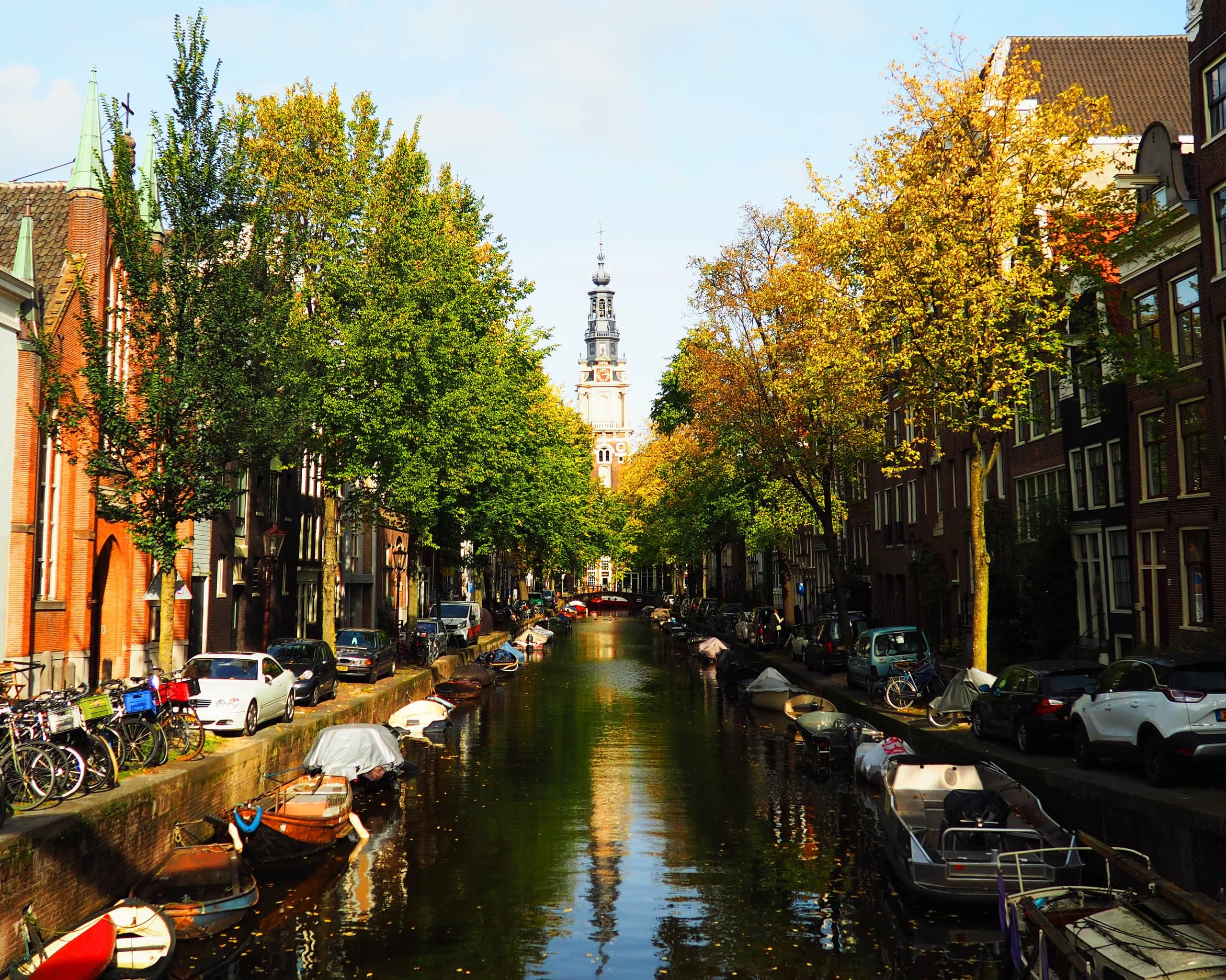 Autumn canal lined with trees and boats in Amsterdam, peaceful cruise