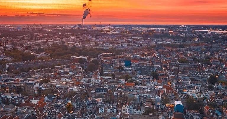 Sunset aerial view over Amsterdam cityscape and canals