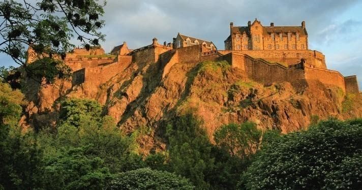 Sunset fortress atop rocky crag offering dramatic castle views