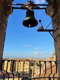 View from bell tower overlooking terracotta rooftops and cityscape