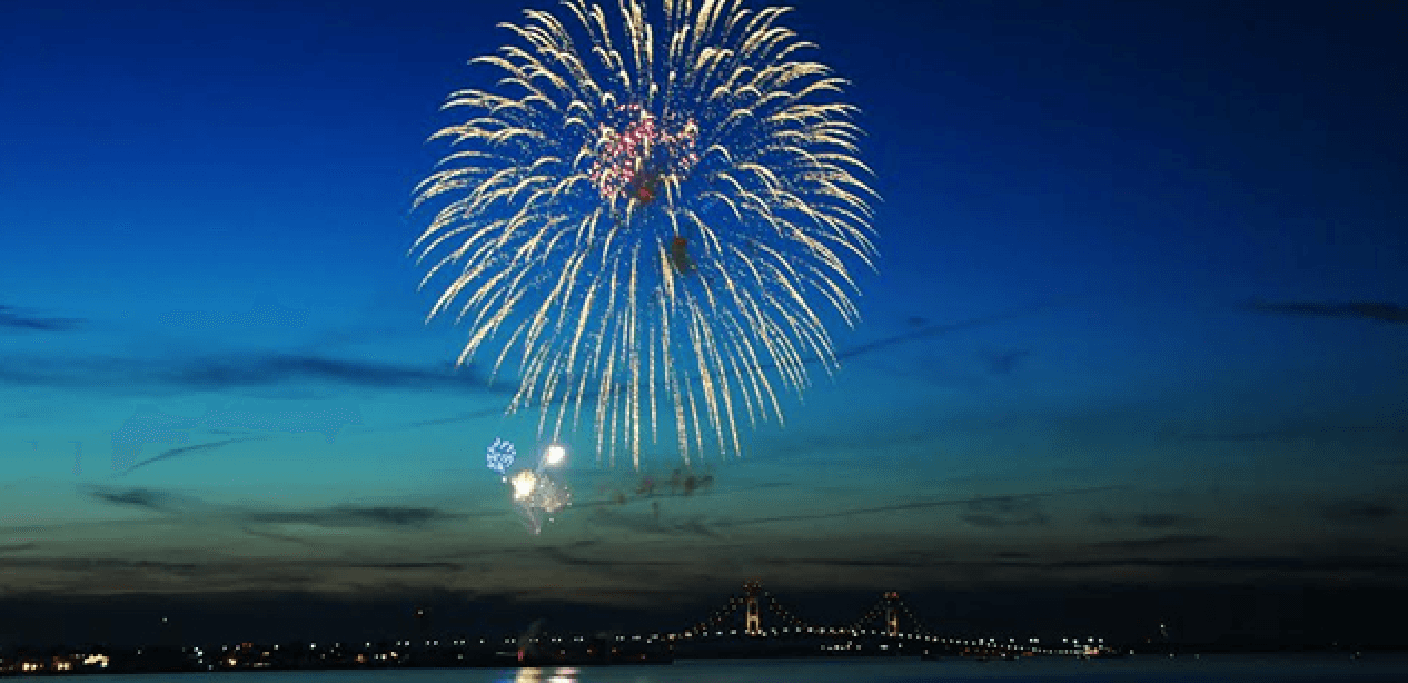 Fireworks display over coastal bay at dusk, waterfront celebration