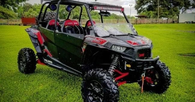 Side-by-side UTV parked on grassy field for off-road tour