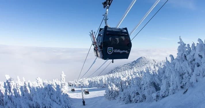 Gondola cabin gliding over snowy forested slopes and trees