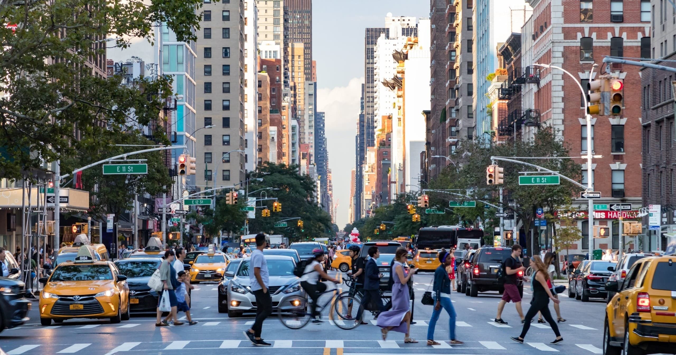 Pedestrians crossing busy Manhattan avenue with taxis