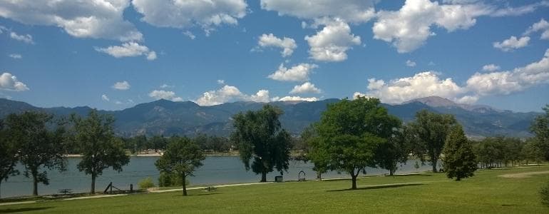 Scenic lakeside park with mountains under blue sky, Colorado