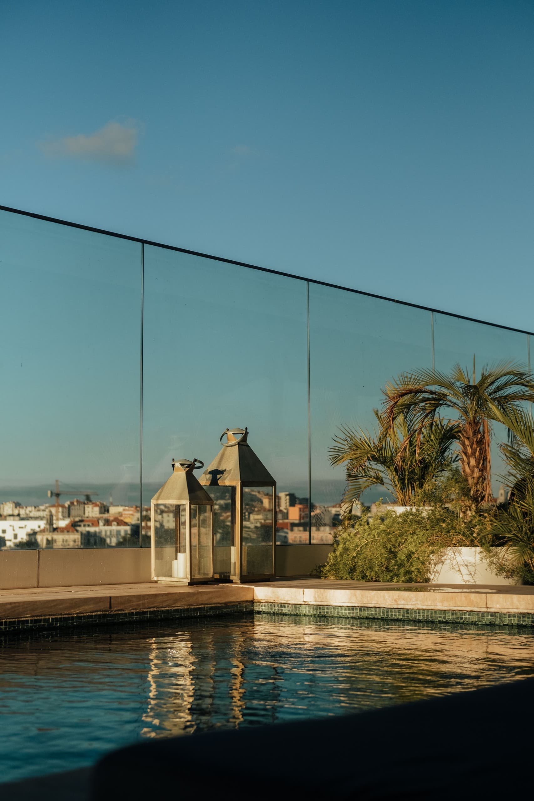 Glass-railed rooftop pool with panoramic urban skyline view