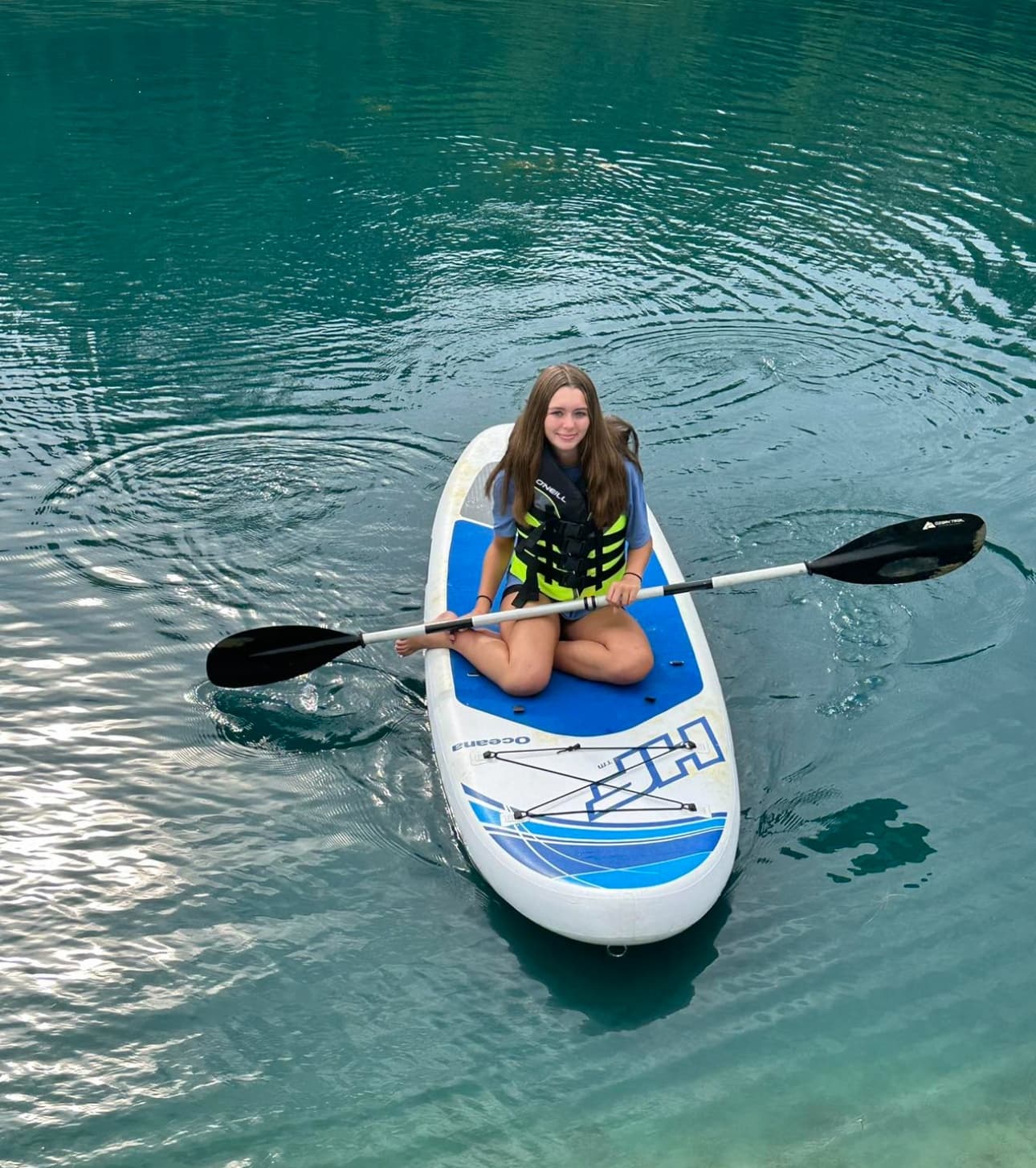 Paddleboarder enjoying calm crystal-clear lake waters