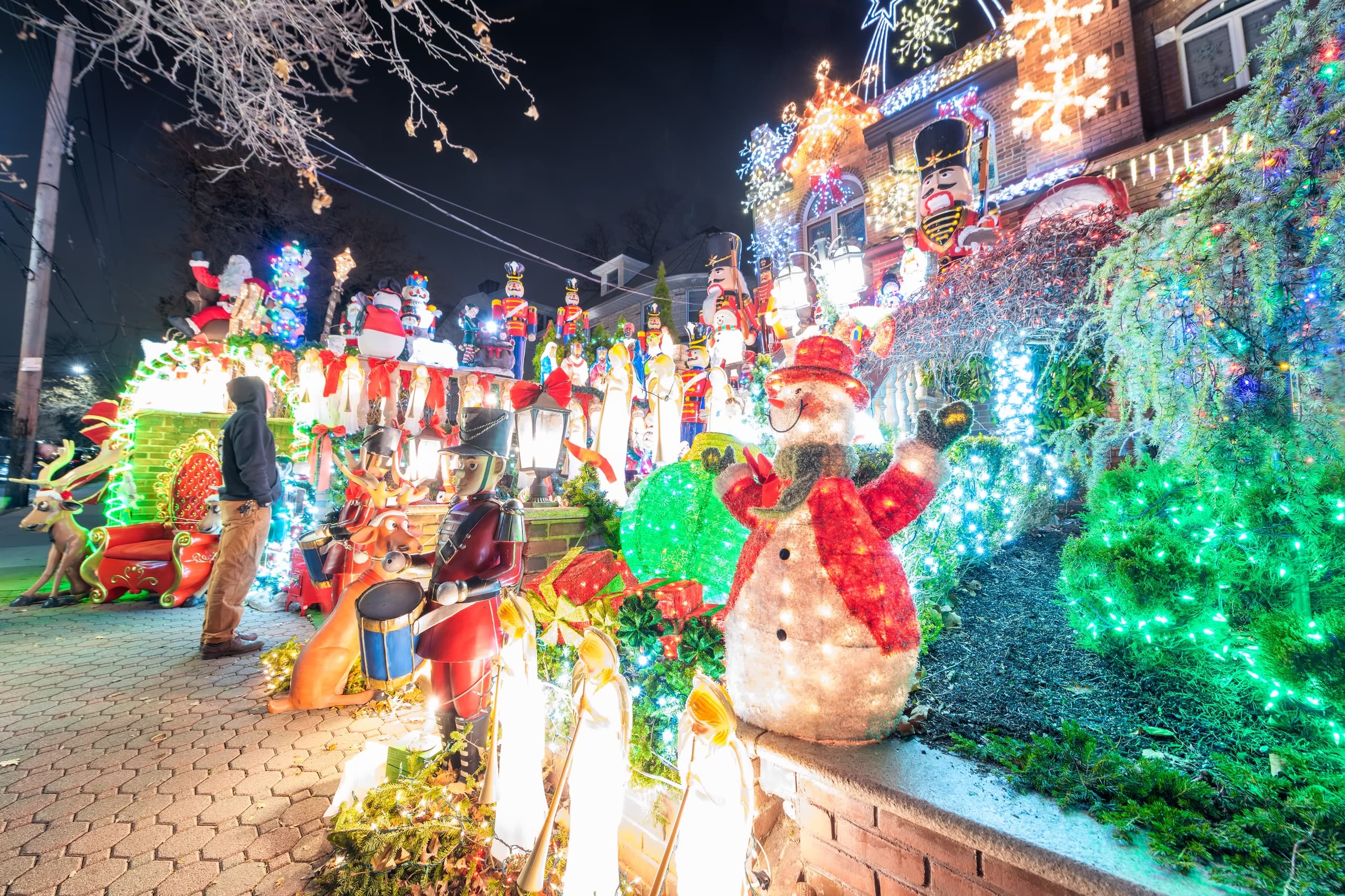 Neighborhood house lawn covered with bright outdoor Christmas display