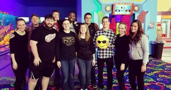 Group of friends at indoor arcade entertainment center posing