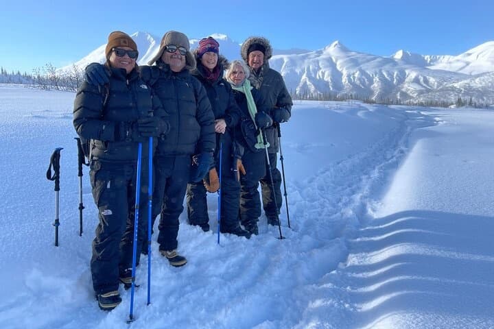 Guided snowshoe hike with group against mountain panorama