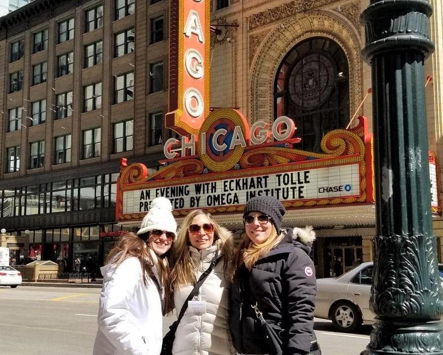 Group posing by Chicago Theatre marquee on downtown walking tour