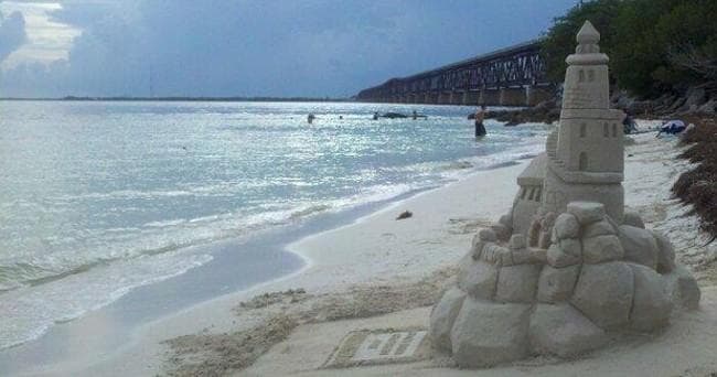 Sandcastle on wide Gulf Coast beach at sunset, shoreline view